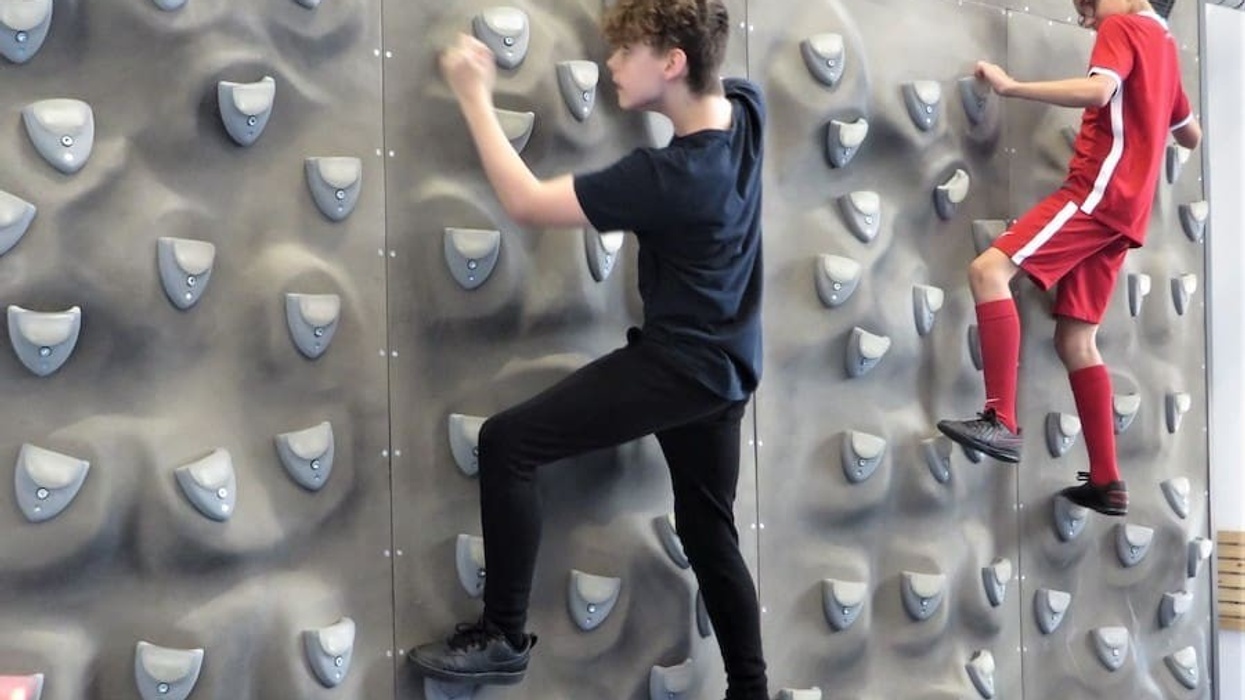 2 Children climb on a climbing wall