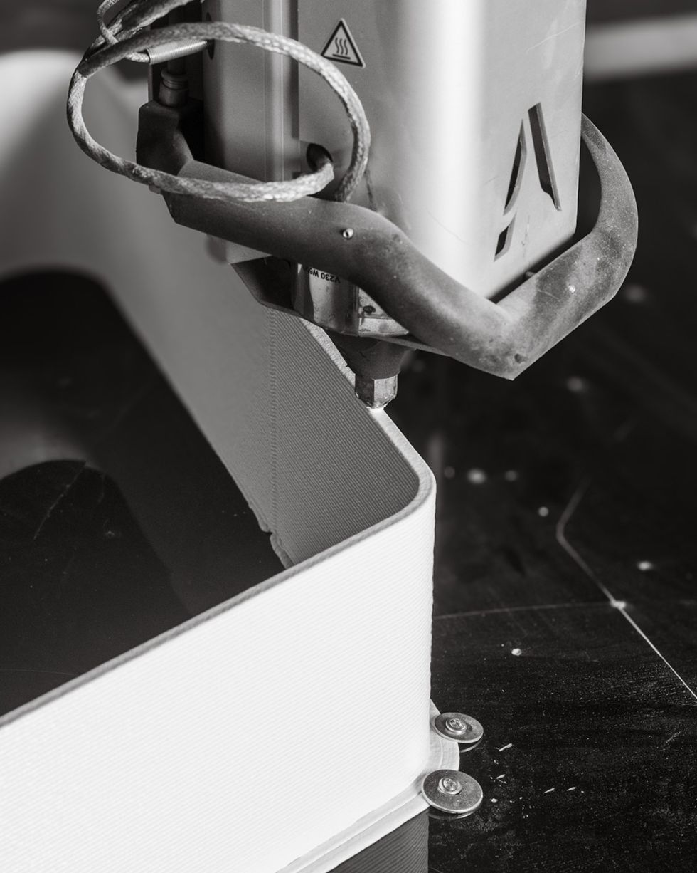 3D printer extruding layers of material in black and white.