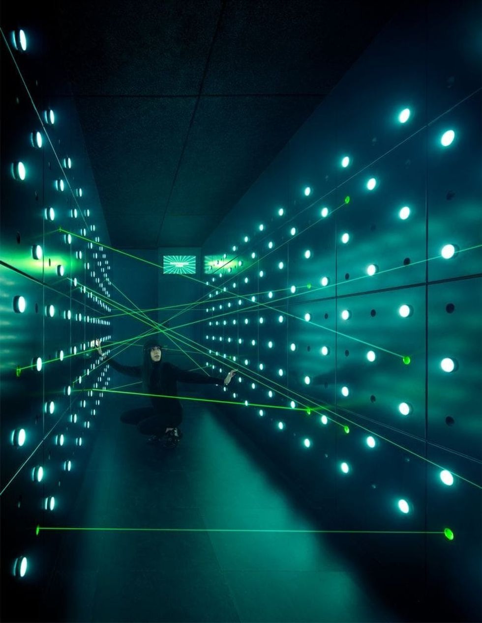 A female visitor trying out the Special Ops laser challenge at SPYSCAPE