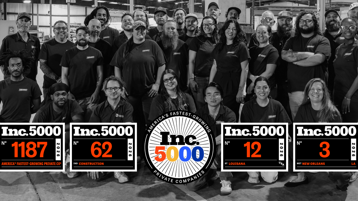A group photo of Downtown FabWorks employees with several "Inc. 5000" award plaques.