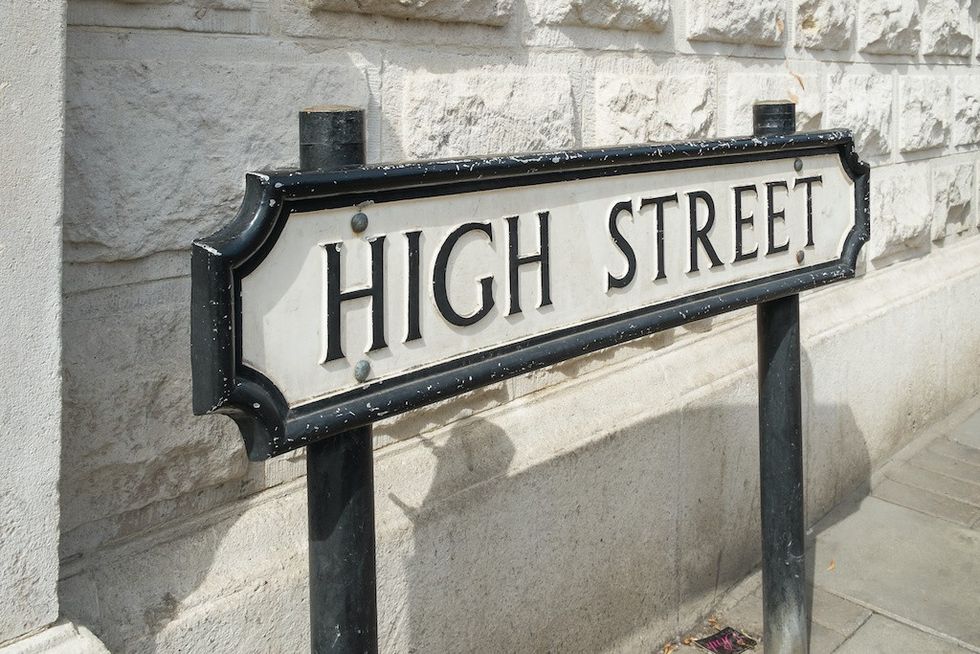 A High Street road sign in front of a white wall