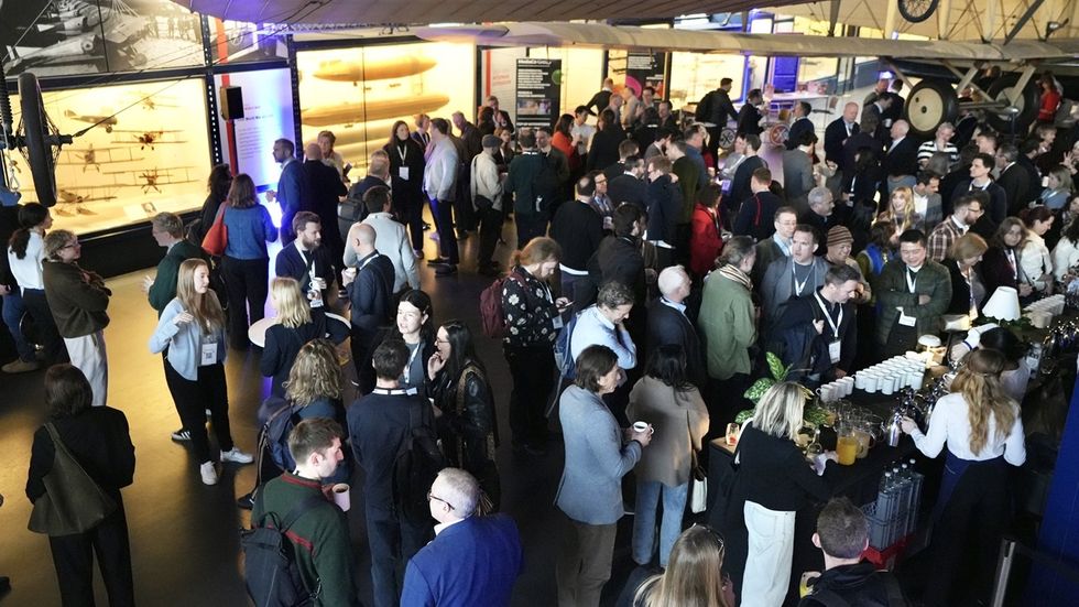 A large group of visitor experience professionals mingling at an indoor networking event named InnovateX.