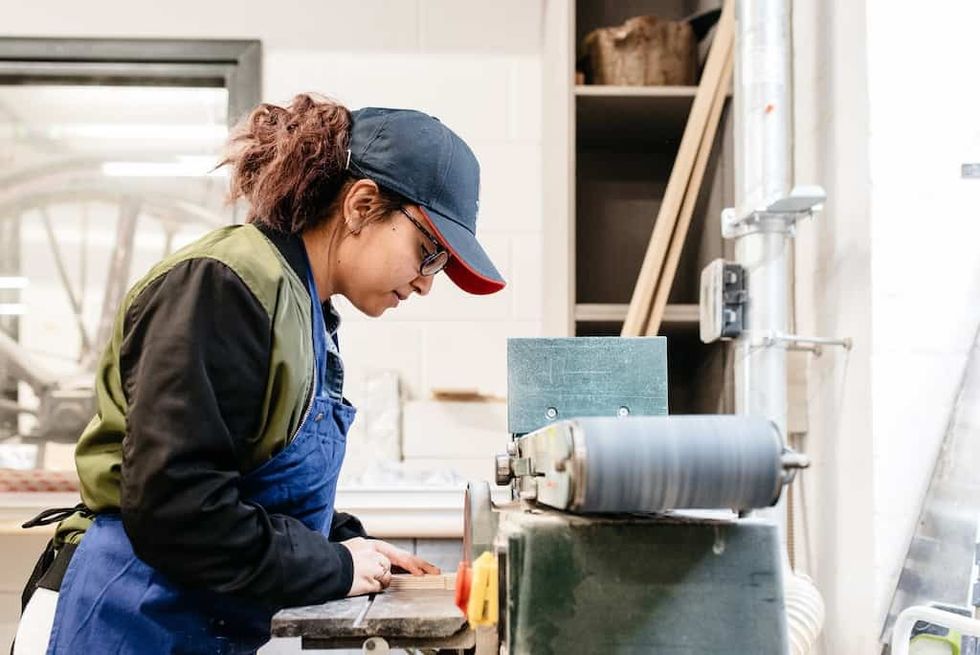 A maker uses the sanding machine in the Workshop at the Museum of Making