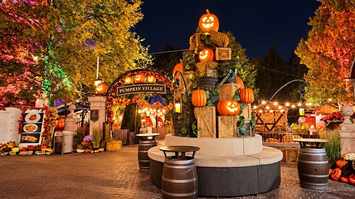 A nighttime pumpkin village decorated with glowing jack-o’-lanterns and autumn leaves.