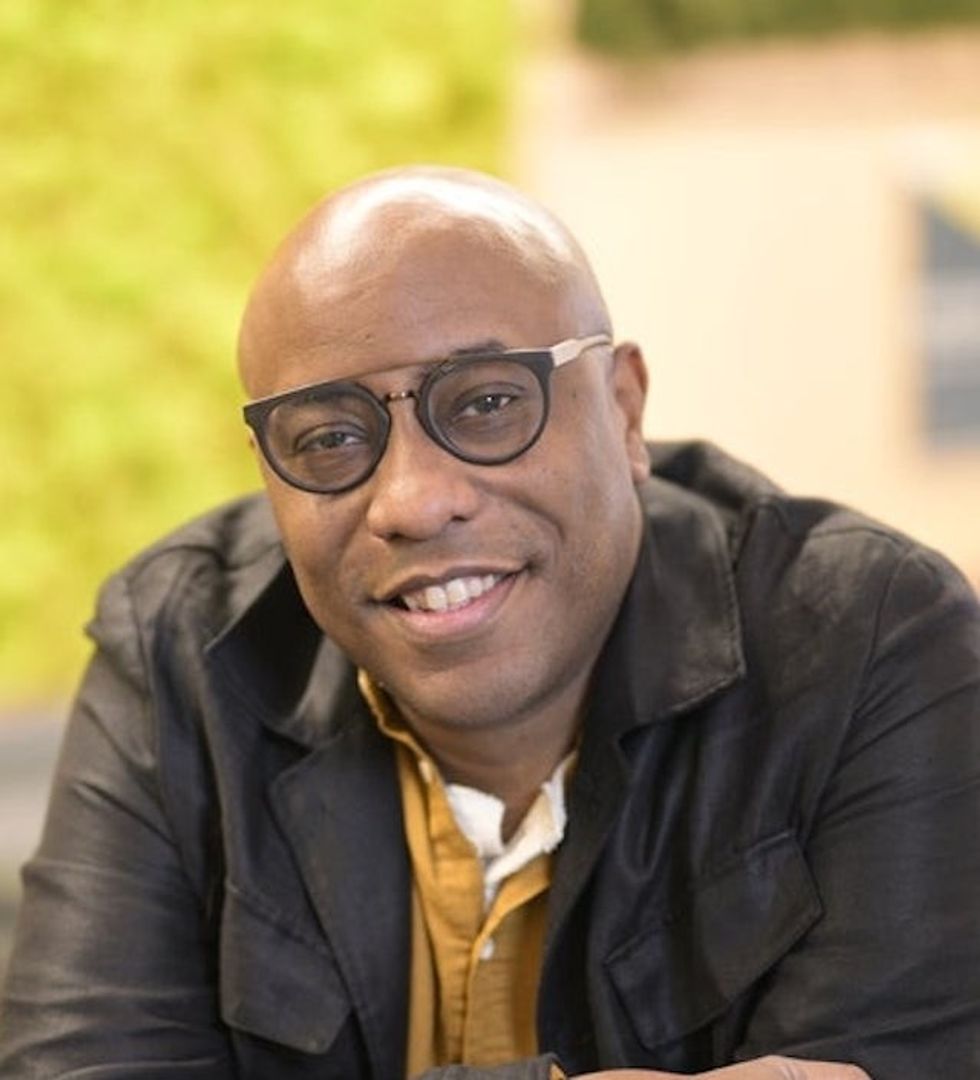 A smiling person named Dan Picard with glasses and a jacket, seated in front of a blurred green background.