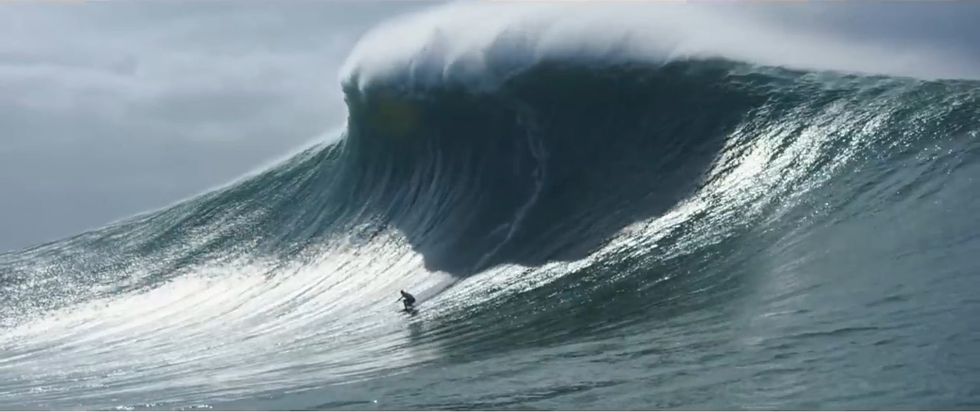 a surfer surfs a giant wave