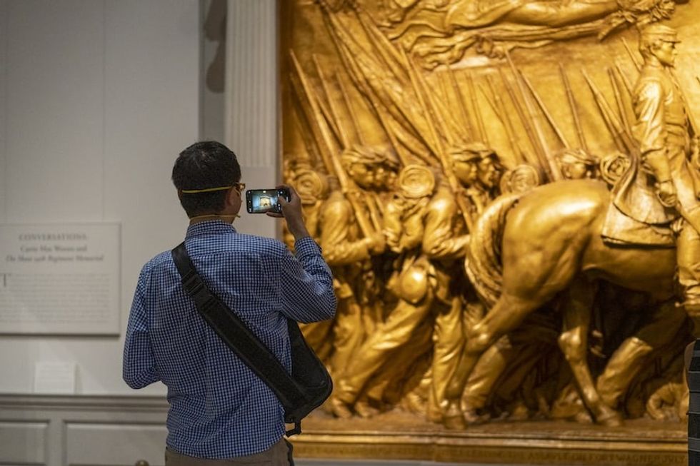 A visitor captures Augustus Saint-Gaudens’ The Shaw 54th Regiment Memorial