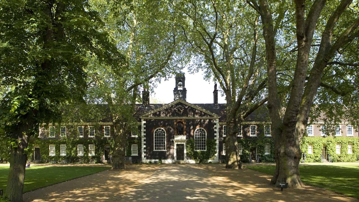 A wide-angle shot of the Museum of the Home Geffrye almshouses in the sunshine. The view is down the central path towards the exterior of the Chapel, one of the museums documenting the pandemic