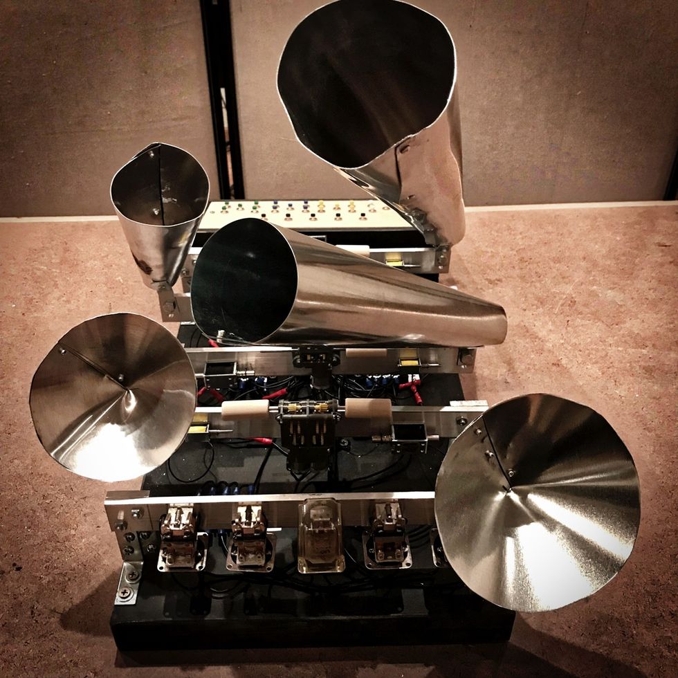 Abstract sculpture with metal cones and electronic components on a table.