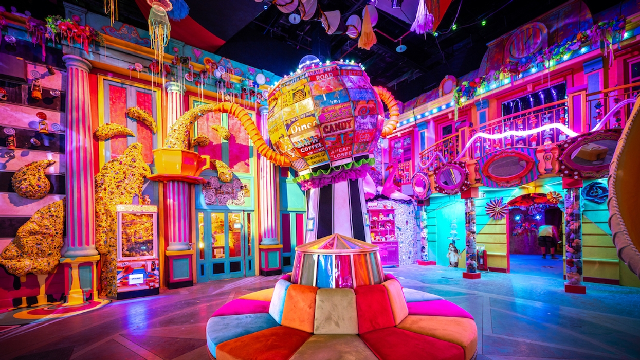 Absurd City from Wake the Tiger, a colorful, whimsical indoor space with vibrant lights and eclectic decorations.