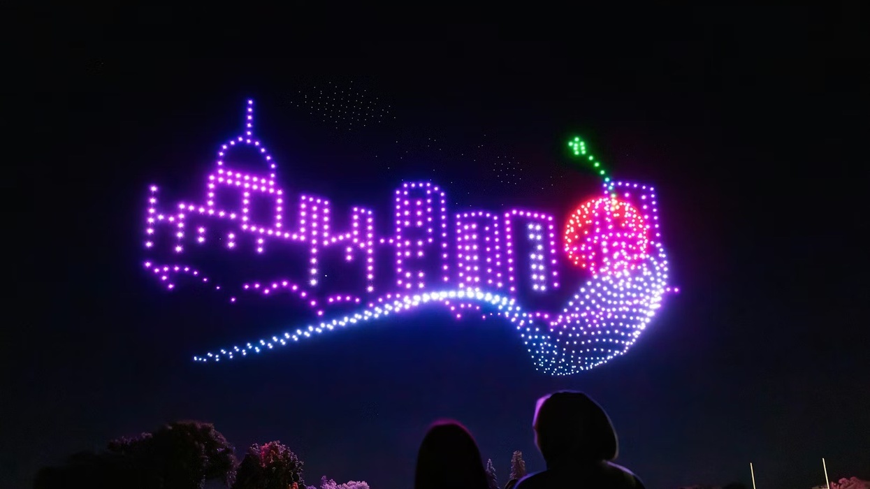 Aerial Illuminations drones in the shape of a city scape with a spoon and cherry