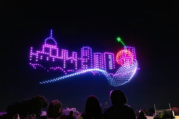 Aerial Illuminations drones in the shape of a city scape with a spoon and cherry