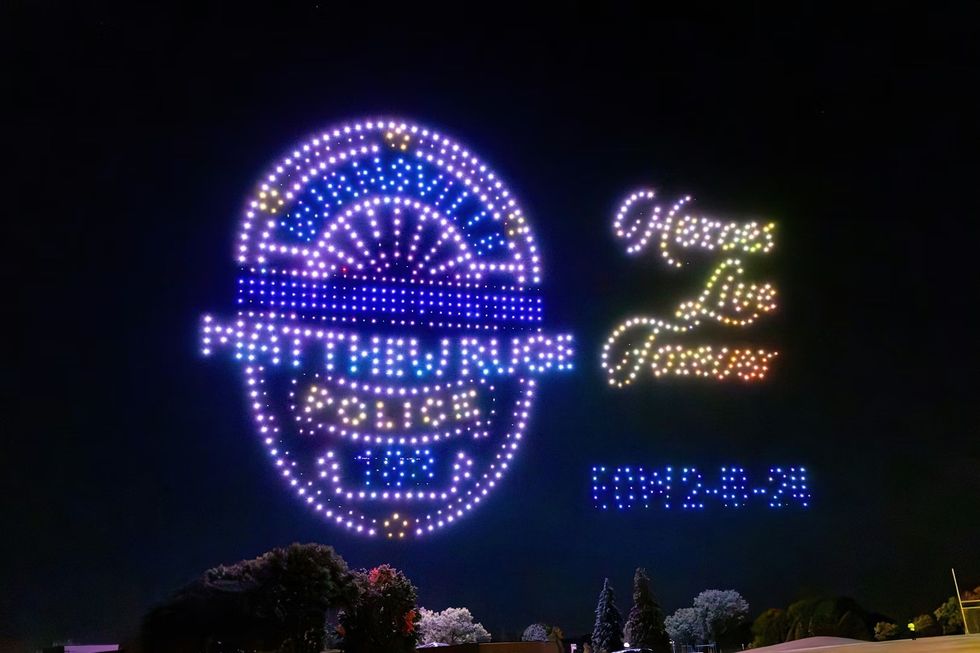 Aerial Illuminations drones shaped like a police badge with memorial text saying Heroes Live Forever
