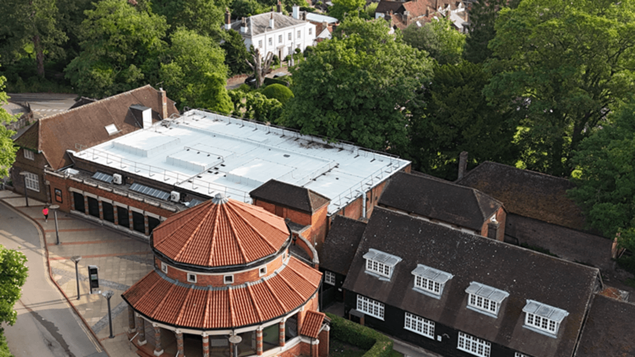 Aerial view of a historic building called the Verulamium Museum with red-tiled roof surrounded by trees and other structures.