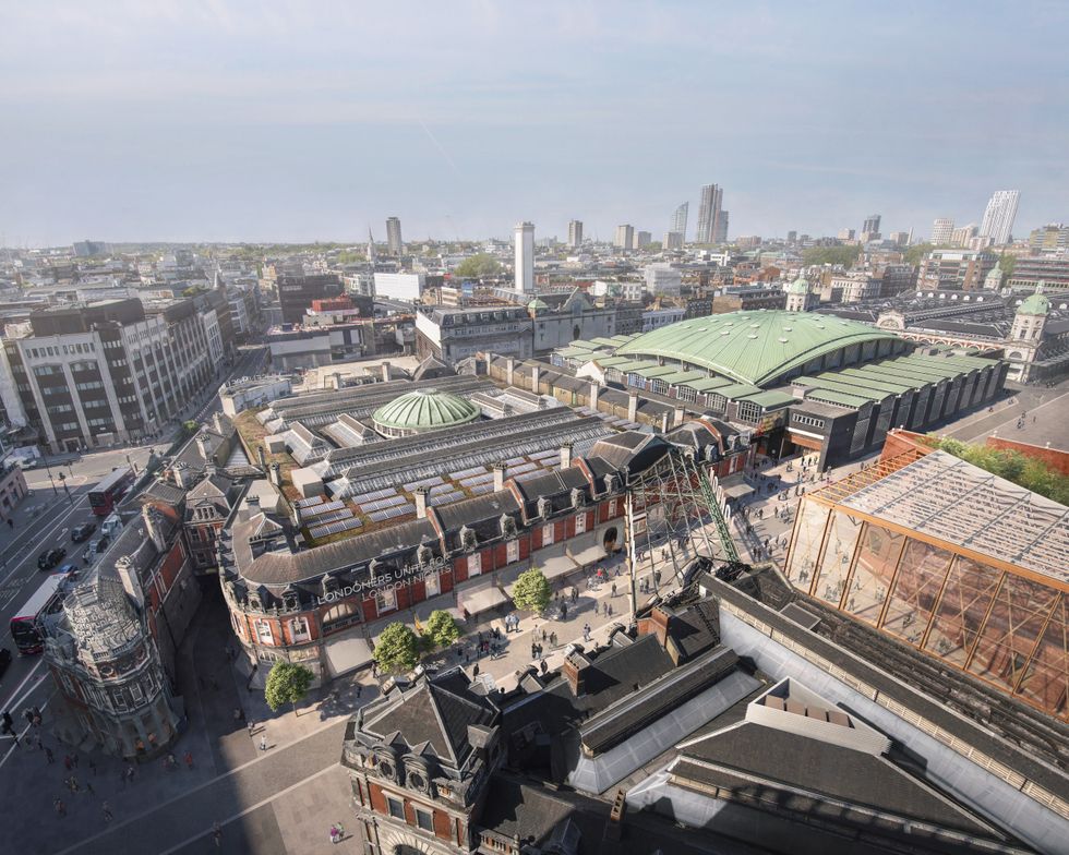 Aerial view of a historic market building with green roofs in a bustling cityscape.