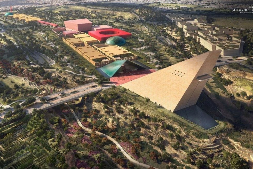 Aerial view of a modern geometric building complex, the Museum of World Cultures, amidst lush greenery.