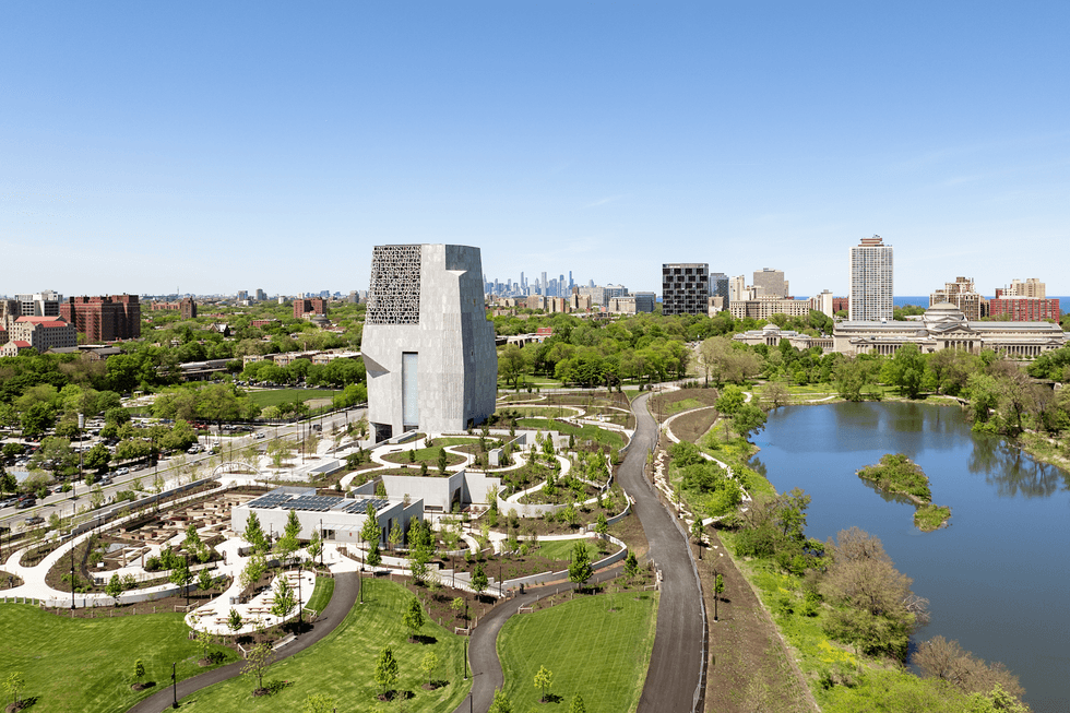 Aerial view of a the Obama Presidential Center with modern architecture and a pond, surrounded by greenery.