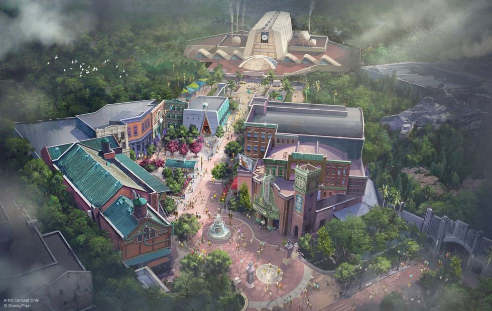 Aerial view of a theme park land called Monstropolis at Disney World with colorful buildings, pathways, and lush greenery.