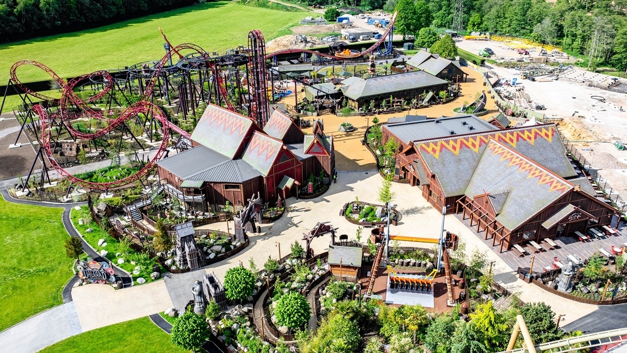 Aerial view of a theme park with roller coasters and colorful buildings.