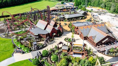 Aerial view of a theme park with roller coasters and colorful buildings.