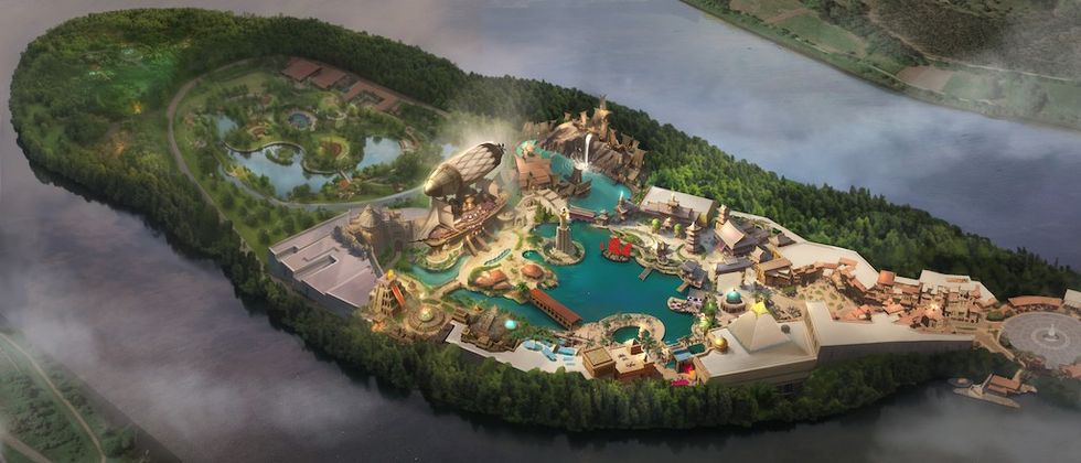 Aerial view of a themed amusement park on a lush, forested island surrounded by water.