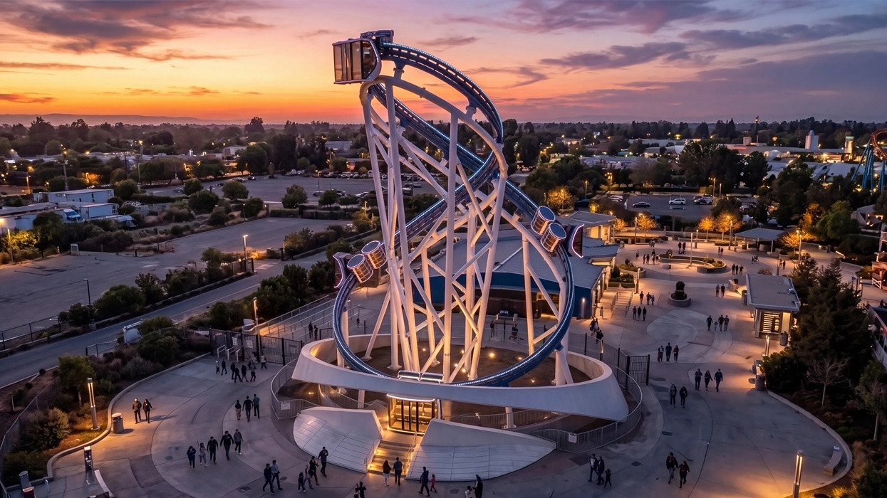 Aerial view of a twisting PM360 steel tower at an amusement park beneath a colourful sunset sky.