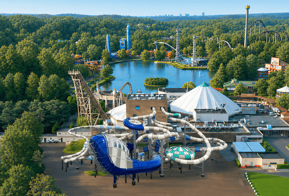 Aerial view of a waterpark with slides, a lake, and surrounding forests.