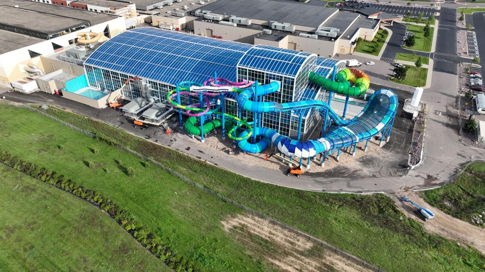 Aerial view of an indoor water park at Kalahari resort with colorful slides and a blue glass roof.