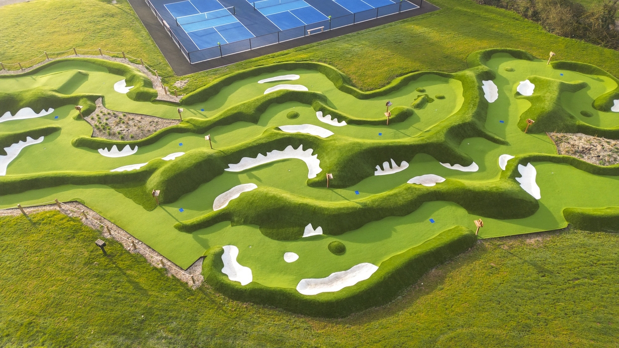 Aerial view of an intricately designed mini-golf course next to tennis courts.