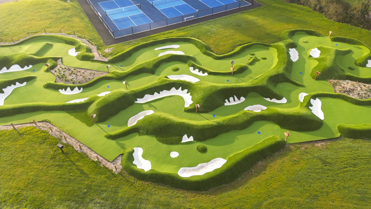 Aerial view of an intricately designed mini-golf course next to tennis courts.