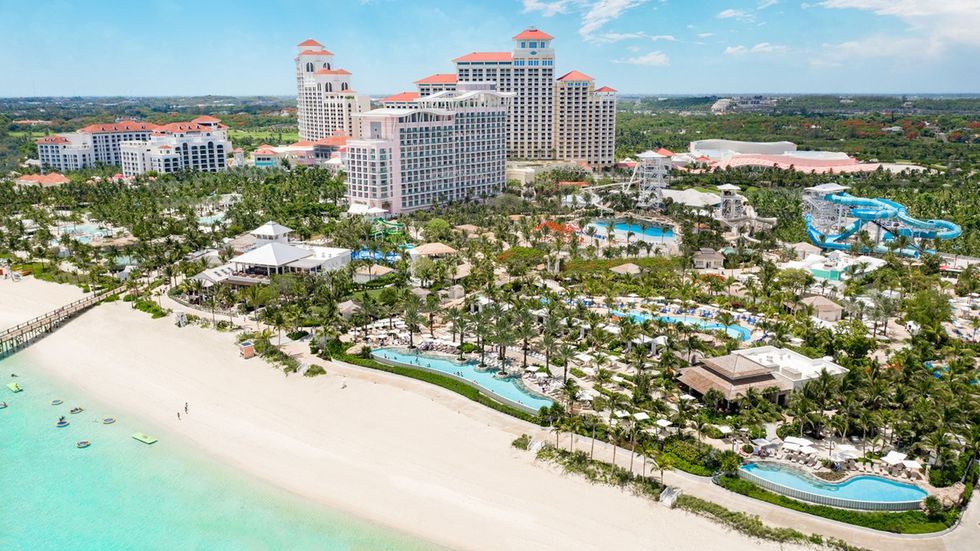 Aerial view of Baha Bay, a beachfront resort with tall hotels, pools, and blue water slides.