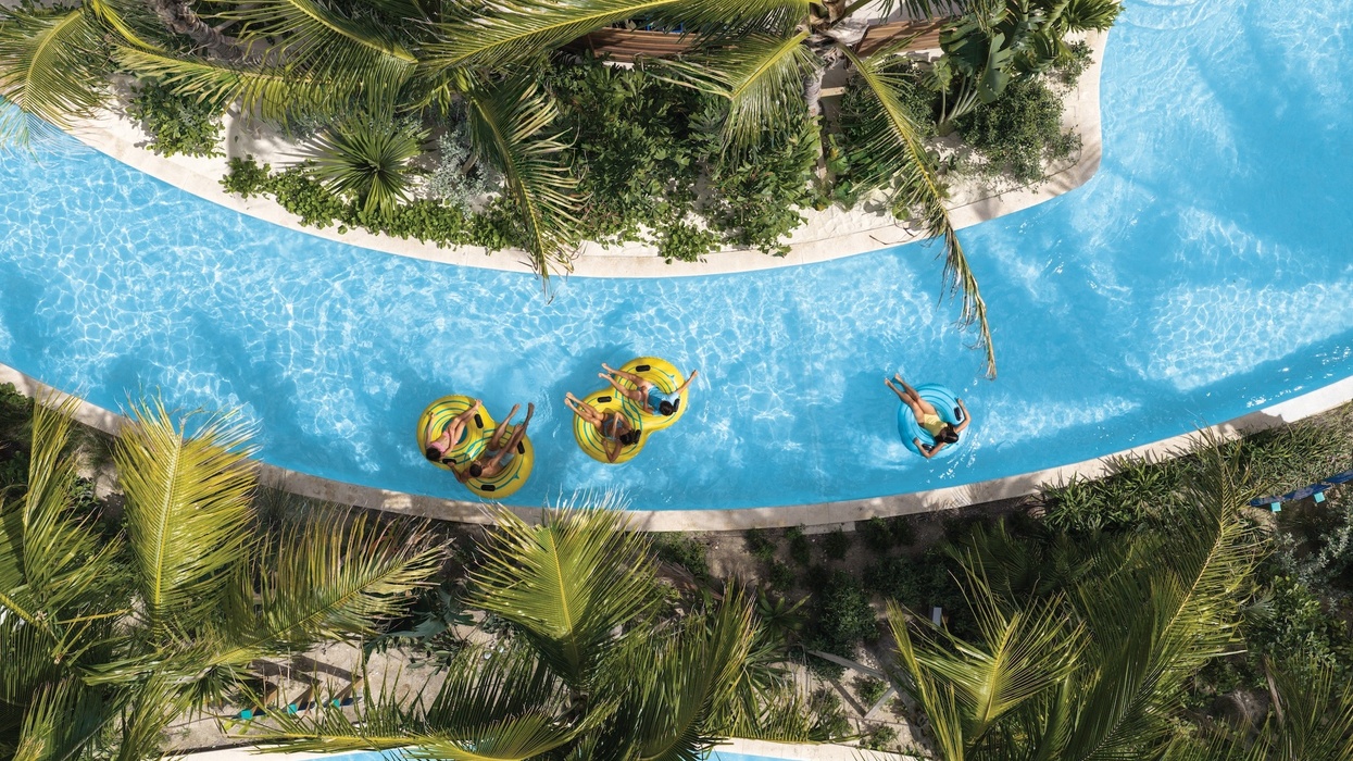 Aerial view of people floating on a lazy river surrounded by lush greenery at Great Tides Waterpark