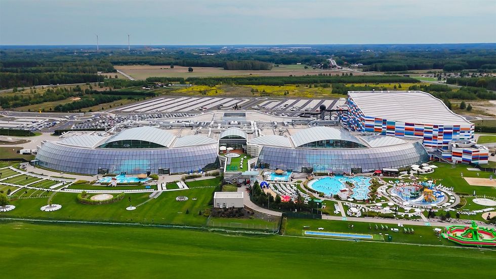 Aerial view of Suntago Water World, a large water park with pools, colorful slides, and surrounding greenery.