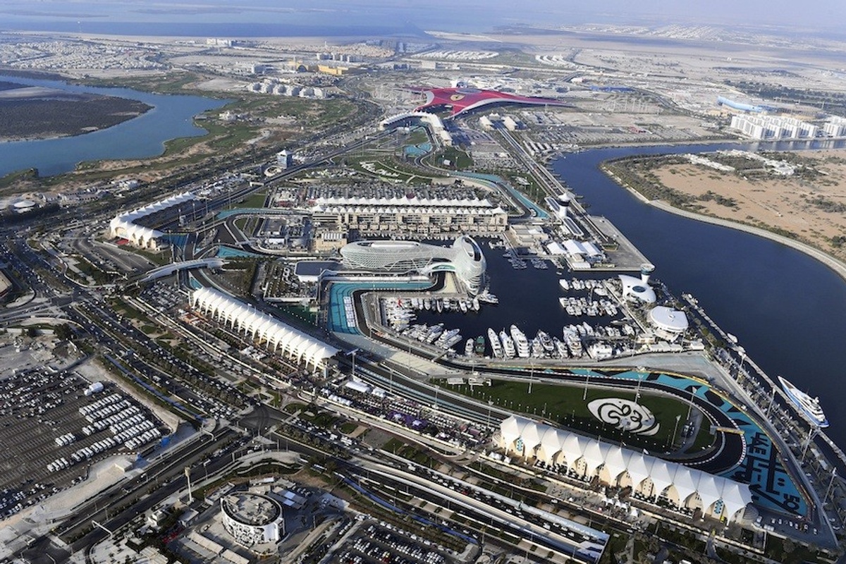 Aerial view of Yas Island attractions and marina with surrounding urban landscape.