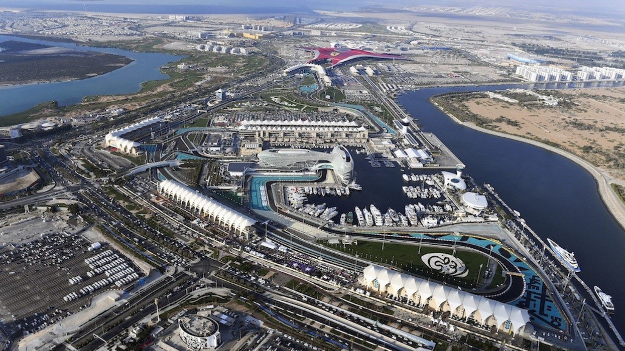 Aerial view of Yas Island attractions and marina with surrounding urban landscape.