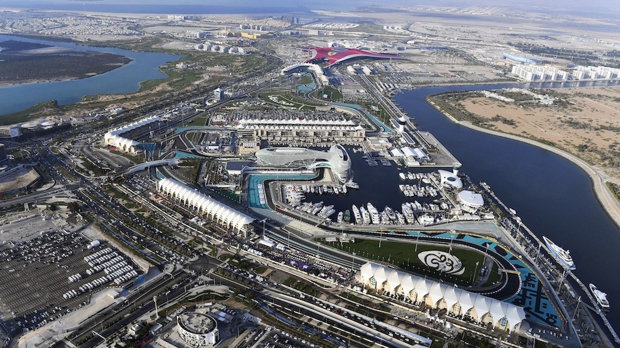 Aerial view of Yas Island attractions and marina with surrounding urban landscape.