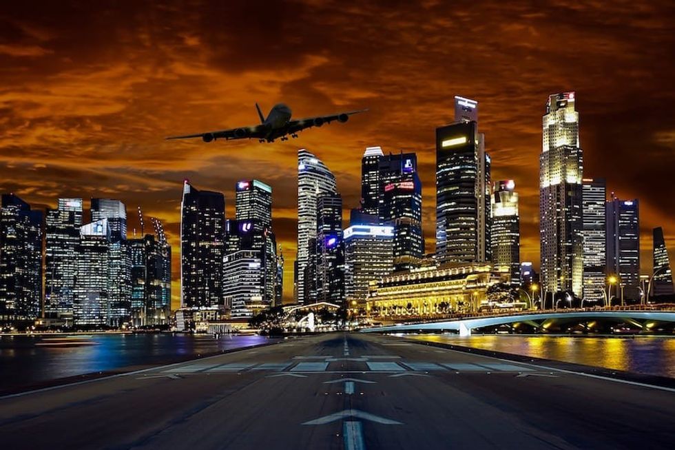 Aeroplane coming in to land over Singapore city at night
