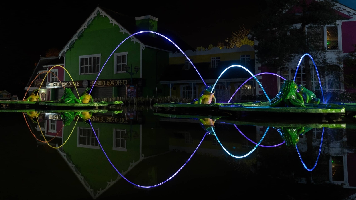 Alton Towers Theme Park entrance at night, with lit streams of water in the Leap Frog Fountain