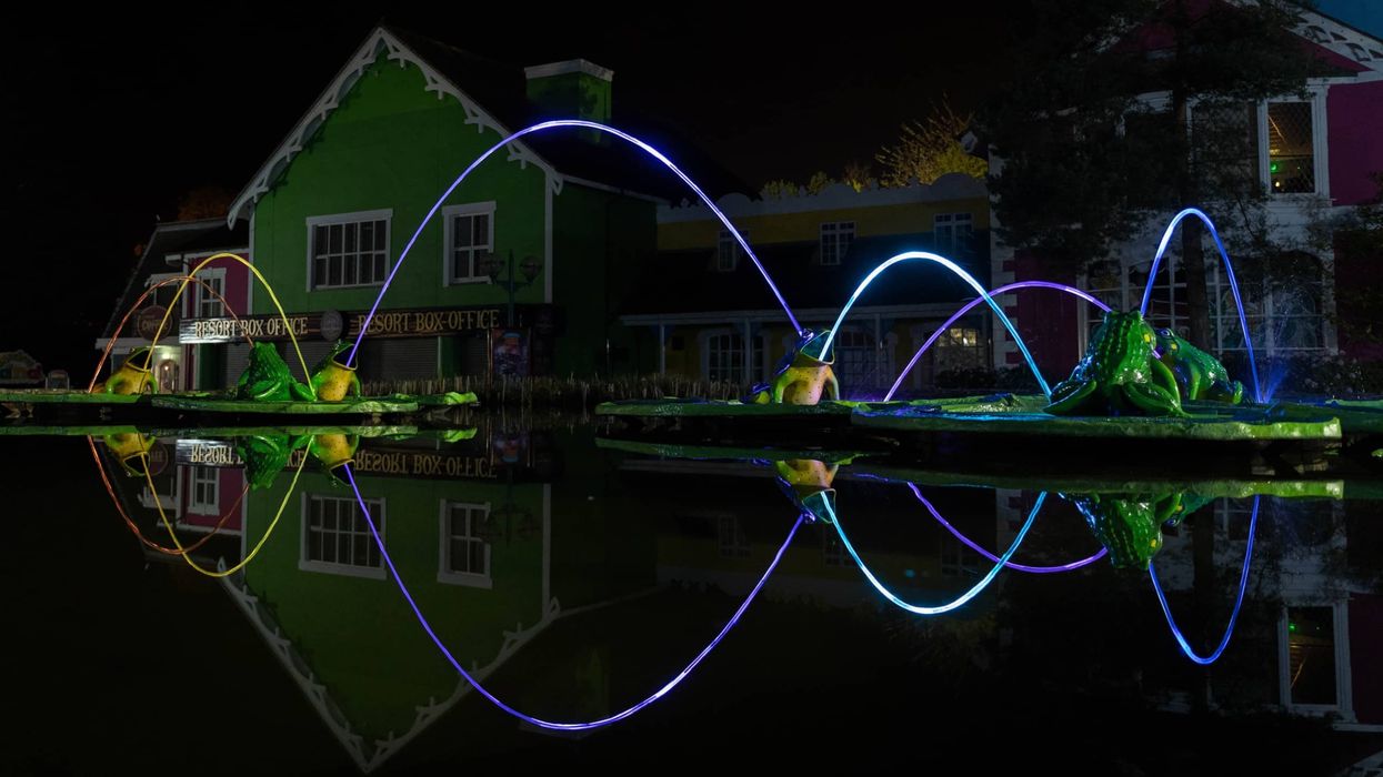Alton Towers Theme Park entrance at night, with lit streams of water in the Leap Frog Fountain