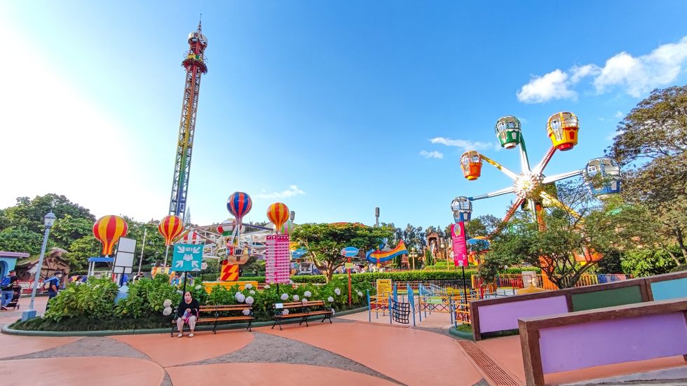 Amusement park called Mundo Petapa with colorful rides, trees, and a clear blue sky.