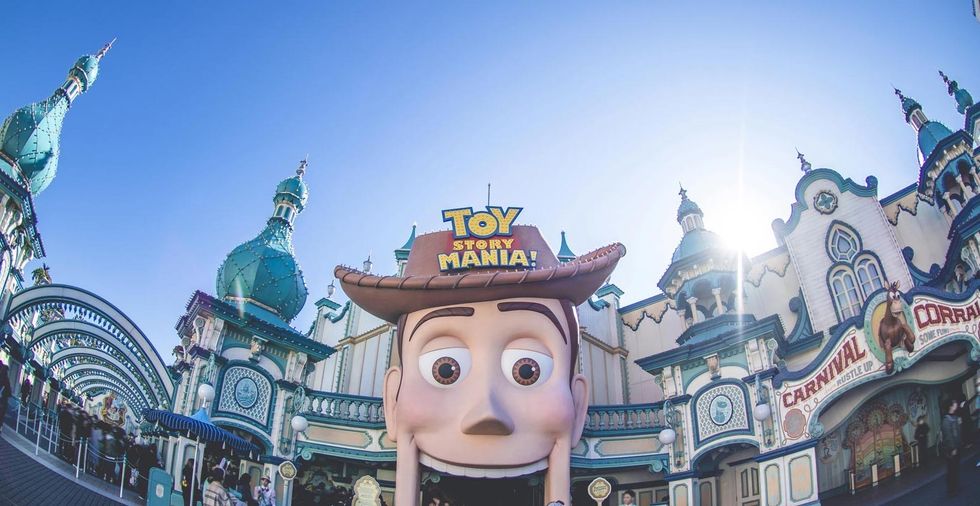 Amusement park entrance with giant Woody head and "Toy Story Mania!" sign.