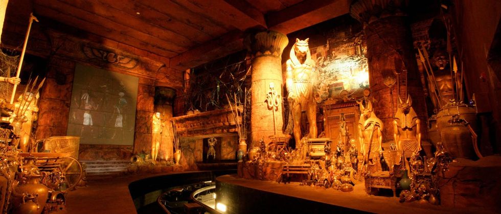 Ancient Egyptian-themed room with statues, artifacts, and a boat ride path.