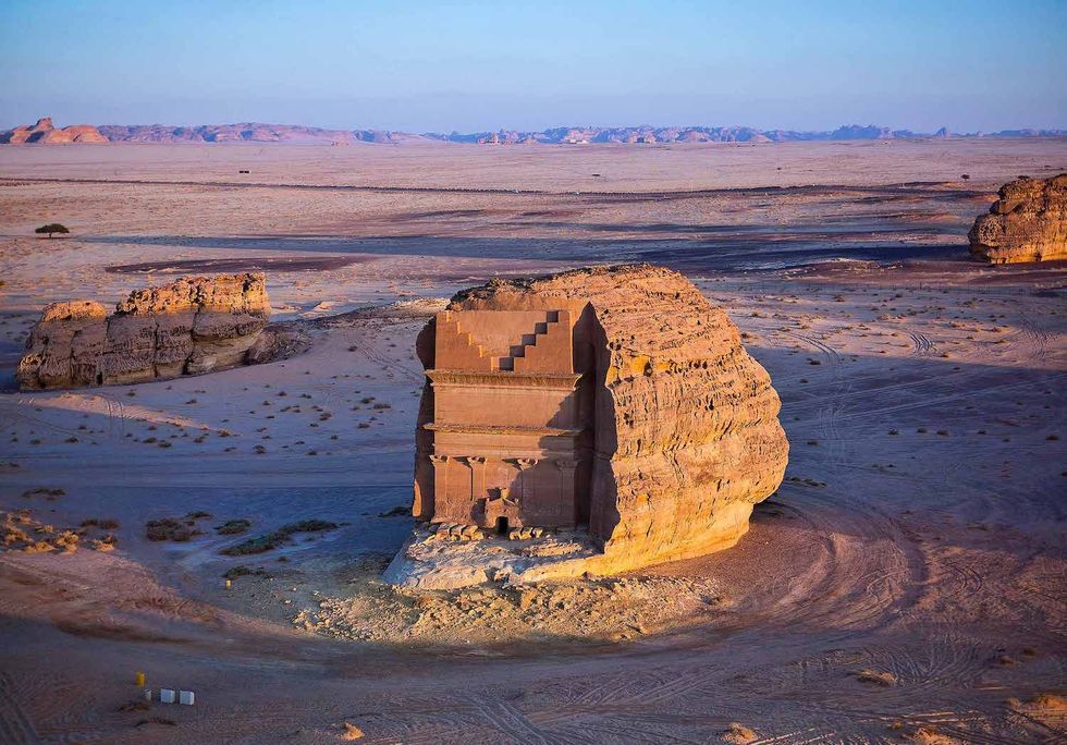 Ancient rock-carved monument at AlUla in a vast desert landscape under a clear sky
