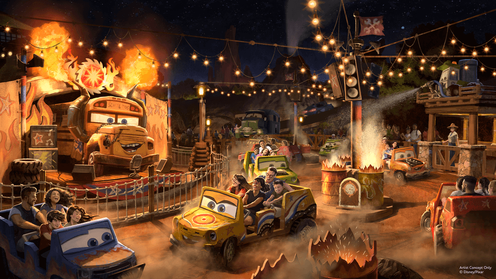 Animated Cars theme park ride at Magic Kingdom with colorful vehicles and bright lights at night.
