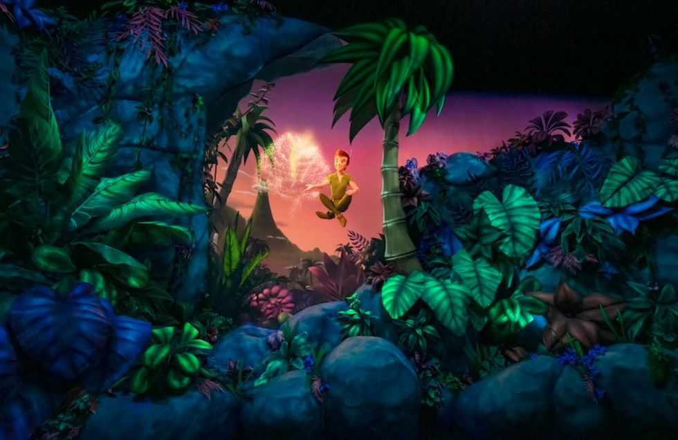 Animated character flying over lush, colorful jungle with glowing fairy at Tokyo DisneySea