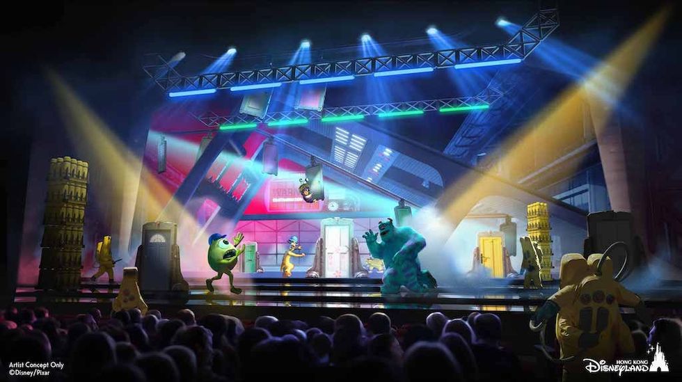 Animated monsters inc. characters perform on a colorful stage in front of an audience.