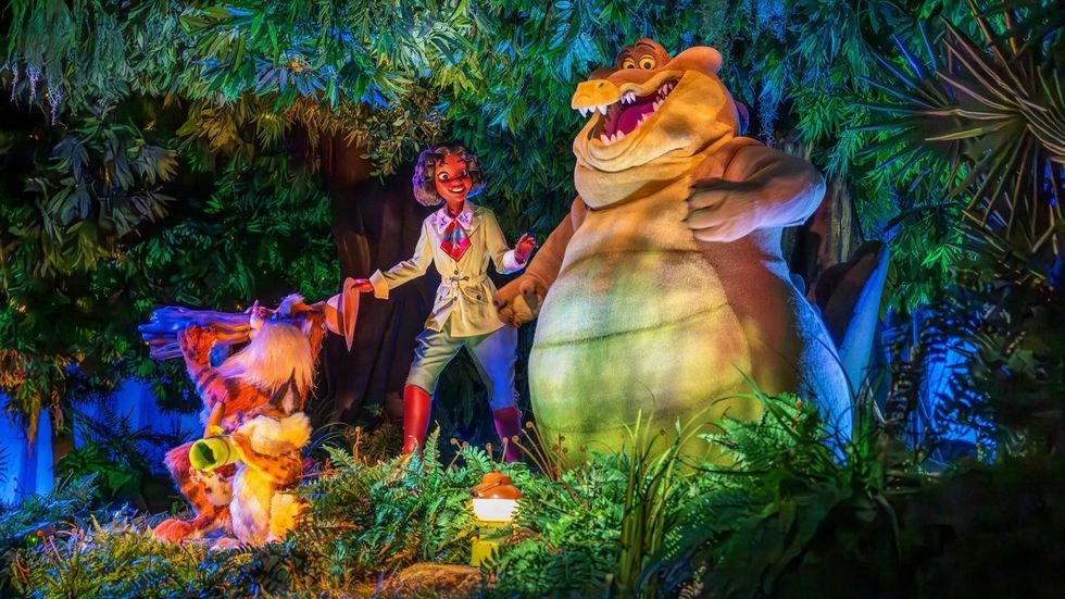 Animatronic characters from a jungle scene during the Tiana's Bayou Adventure ride, featuring a musician, crocodile, and raccoon.
