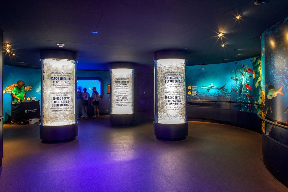 Aquarium exhibit with pillars highlighting plastic waste impact on oceans.