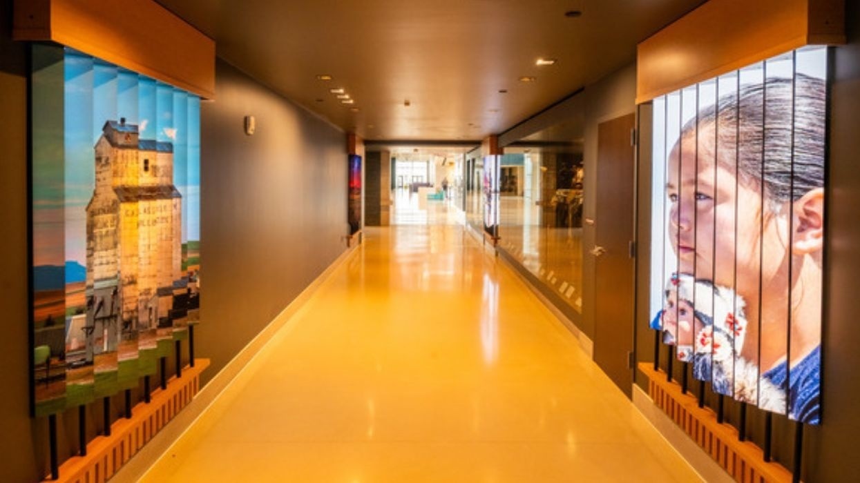Art-filled hallway at Montana Heritage Center, with bright yellow floor and dual wall displays.