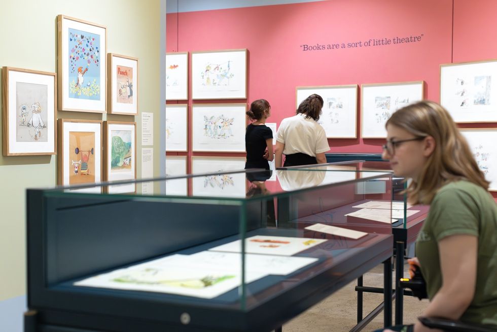 Art gallery called the Quentin Blake Centre for Illustration with displays and people viewing illustrations.